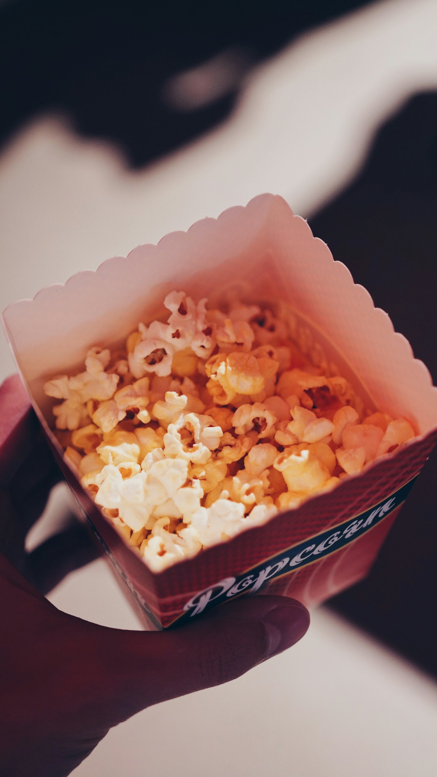 A box of popcorn ready to be shared with a cup of tea